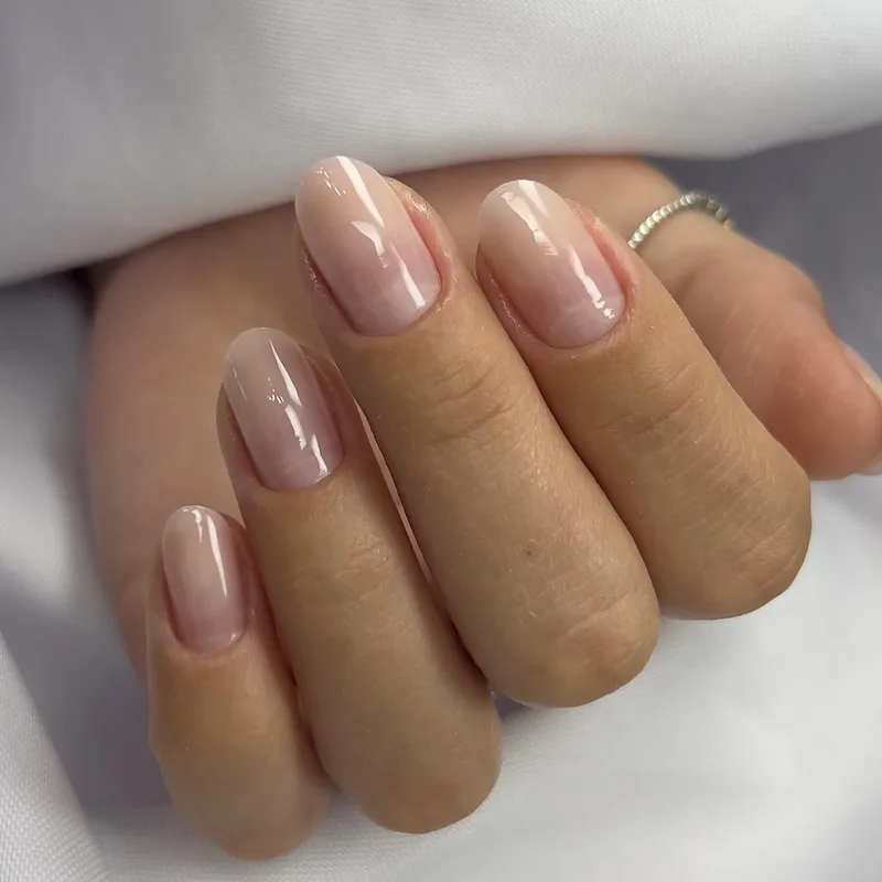 Unhas ovais com degradê baby boomer natural e acabamento brilhante