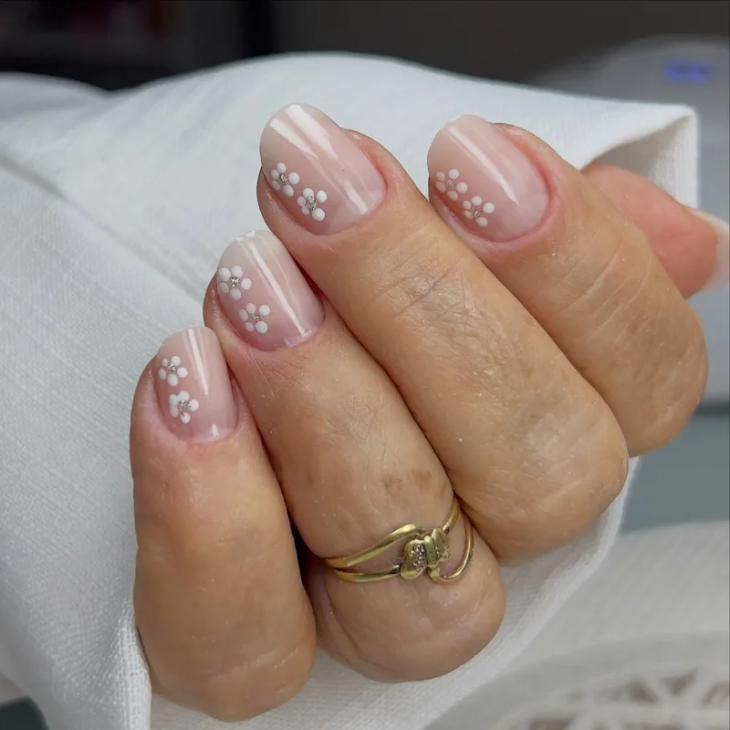 Unhas delicadas com mini margaridas artesanais pintadas à mão
